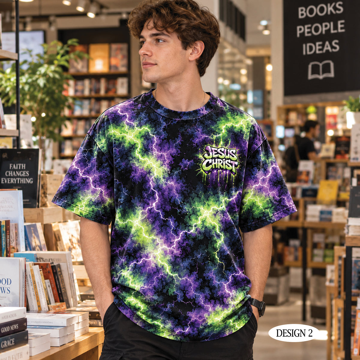 A man wearing a black t-shirt with a purple and green lightning bolt tie-dye pattern, standing in a bookstore. The shirt features a graphic on the left chest that reads 'JESUS CHRIST' in a stylized font.