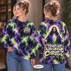 Two women modeling a long-sleeve crewneck sweatshirt shown from the front and back. The sweatshirt features a purple and green lightning tie-dye pattern with a graphic of Jesus Christ and the text 'JESUS CHRIST' on the back, and a matching small chest graphic on the front.